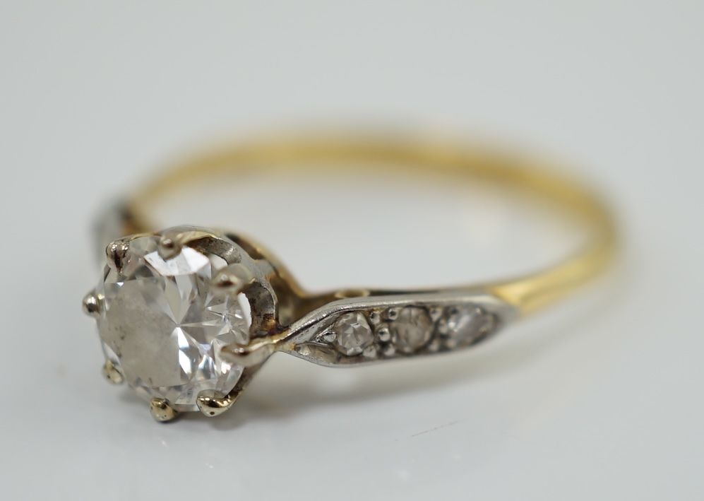 A modern 18ct gold and single stone diamond set ring, with six stone diamond chip set shoulders